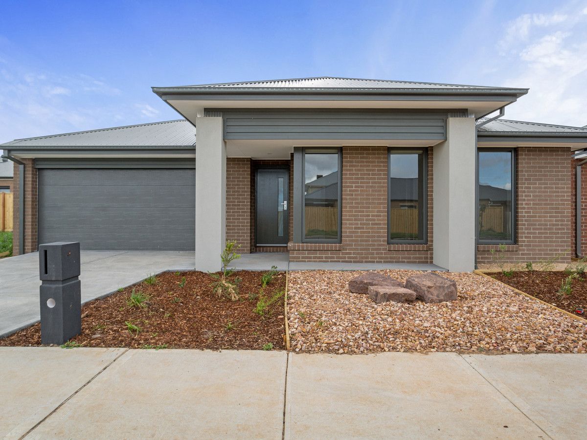 A modern single-story house with a landscaped front yard, grey garage door, and brick exterior.